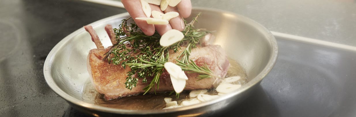 Während des Bratens Knoblauch, Rosmarin und Thymian hinzufügen.