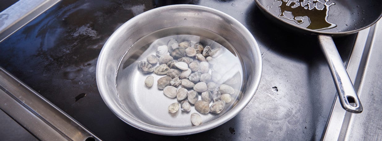 Venusmuscheln ca. 30 Minuten in Salzwasser wässern.