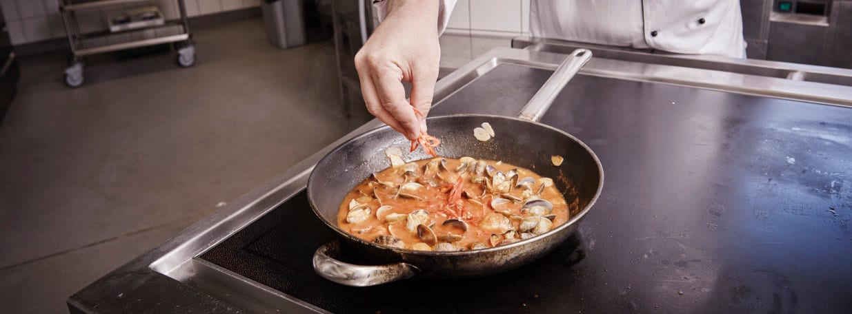 Tomatensauce und Peperoncini hinzufügen. Sauce ein wenig reduzieren.