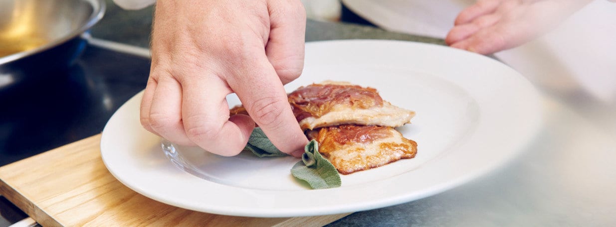 Je zwei Schnitzel auf vorgewärmten Tellern anrichten.