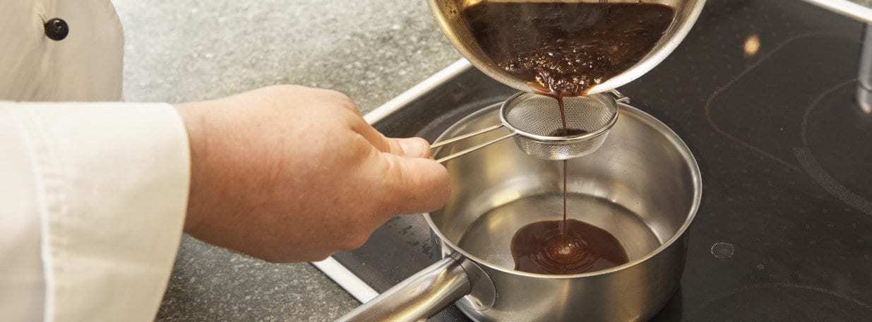 Durch ein dünnes Sieb streichen. Abschmecken und nochmals um die Hälfte einkochen lassen.